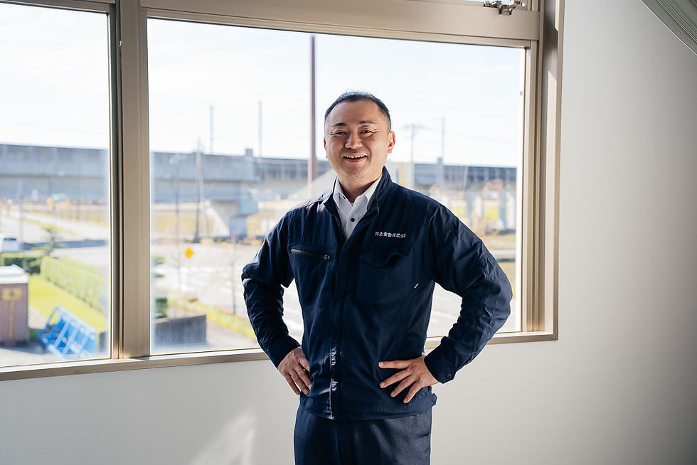 腰に両手をあて、笑顔のMさん