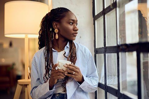 woman-with-braids-enjoying-coffee-by-window-2026-03-26-23-29-56-utc.jpg