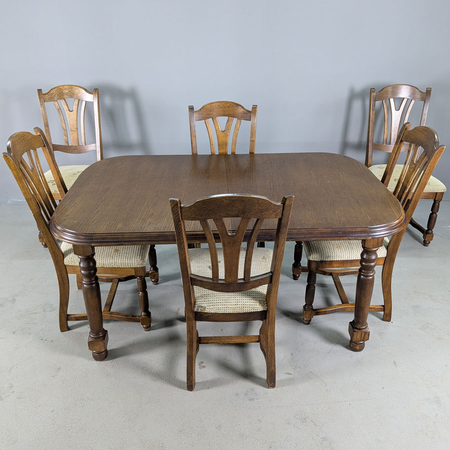 Ąžuolinis valgomojo komplektas su šešiomis kėdėmis ir išskleidžiamu stalu.