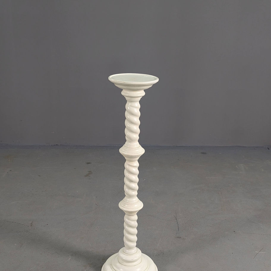 Balta, raižyta žvakidė ant stovo