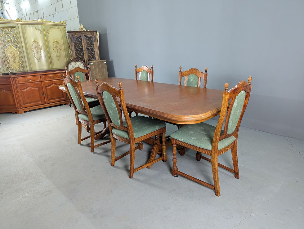 Ąžuolinis valgomojo komplektas su šešiomis žalios spalvos gobelenu aptrauktomis kėdėmis ir išskleidžiamu stalu.