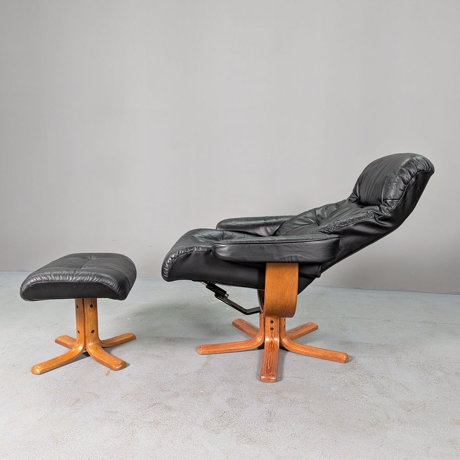 Juodas odinis poilsio krėslas su pufu