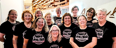 A group of smiling middle aged women wearing t-shirts fo Flourish Experiences