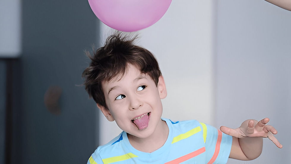A child rubbing a balloon on their hair, causing their hair to stand up due to static electricity.