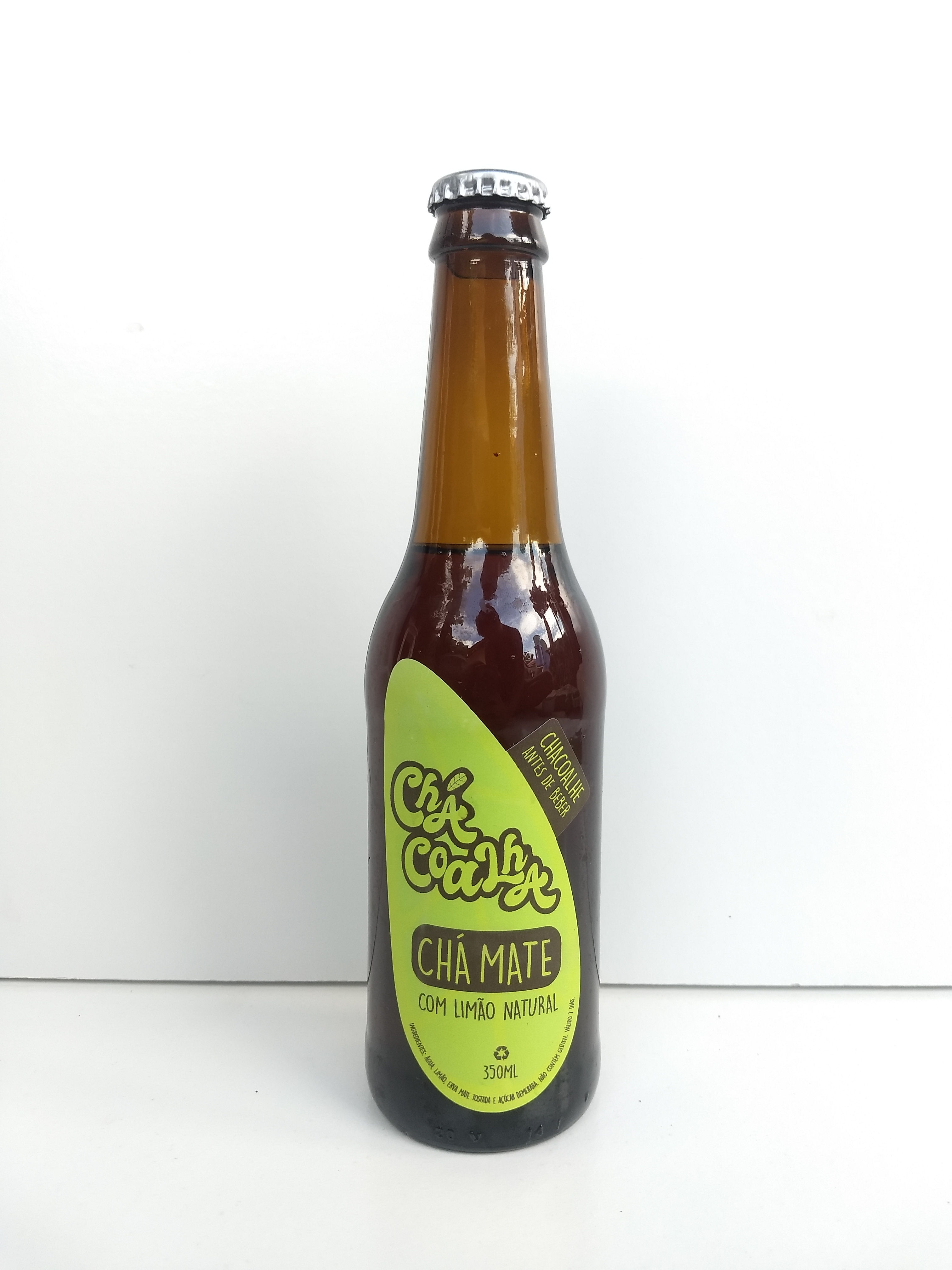 Garrafa long neck escura cheia com tampa prateada e rótulo verde