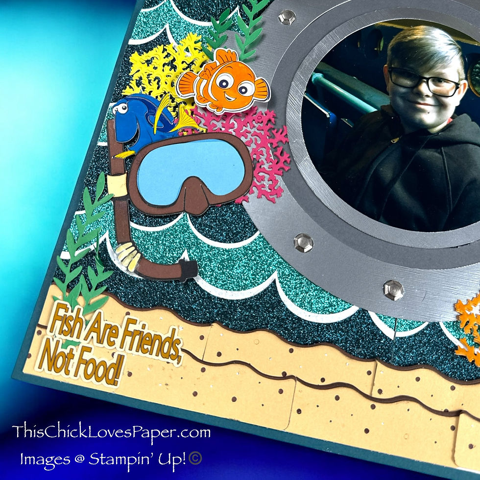 Scrapbook page with porthole photo of smiling person, surrounded by fish, snorkel, and colorful corals. Text reads "Fish Are Friends, Not Food!"