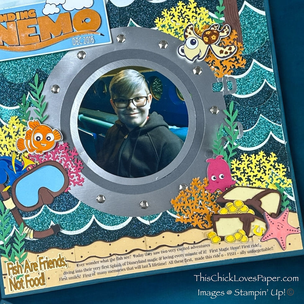Scrapbook page with photo of person in submarine porthole, surrounded by ocean-themed decorations, cartoon fish, and text "Finding Nemo."