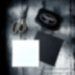 Scissors, black ink pad, and white and black paper on a textured gray background. StazOn ink brand visible. Atmospheric lighting.