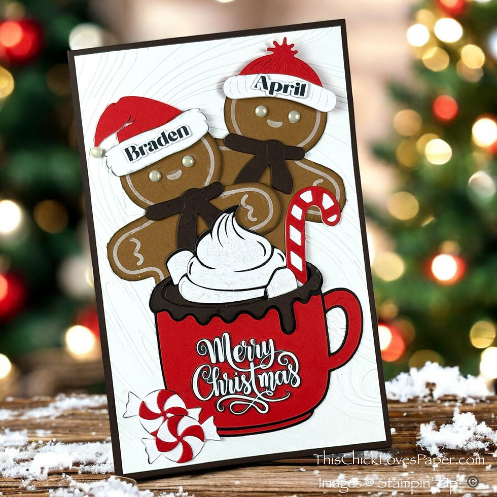 Gingerbread figures with Santa hats labeled "Braden" and "April" in a Christmas card over a red mug reading "Merry Christmas," set against a festive tree background. Handmade Gingerbread Cocoa Christmas Card from This Chick Loves Paper!