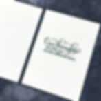 White card on dark surface with text: "Our thoughts are with you at this difficult time," conveying a supportive and empathetic message.