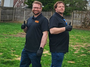 Yard Ninjas workers on a lawn, smiling with thumbs up after performing a dog poop pickup service in the Sylvania & Toledo area. 