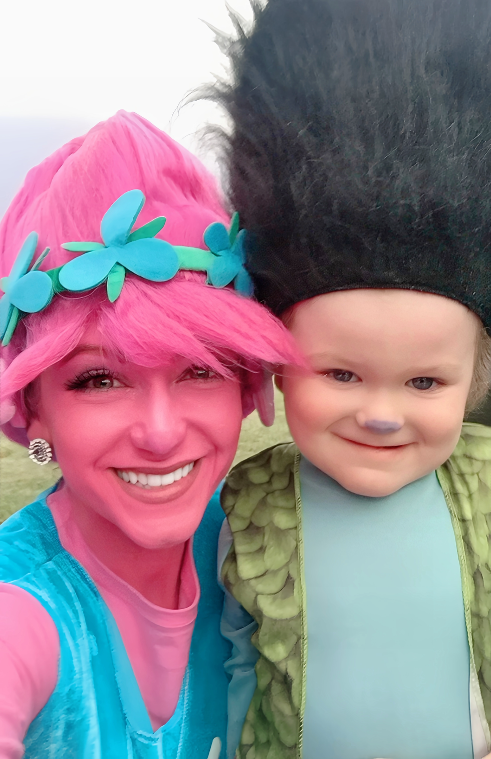 Mother and child dressed as Poppy and Branch from Trolls, enjoying colorful pretend play together