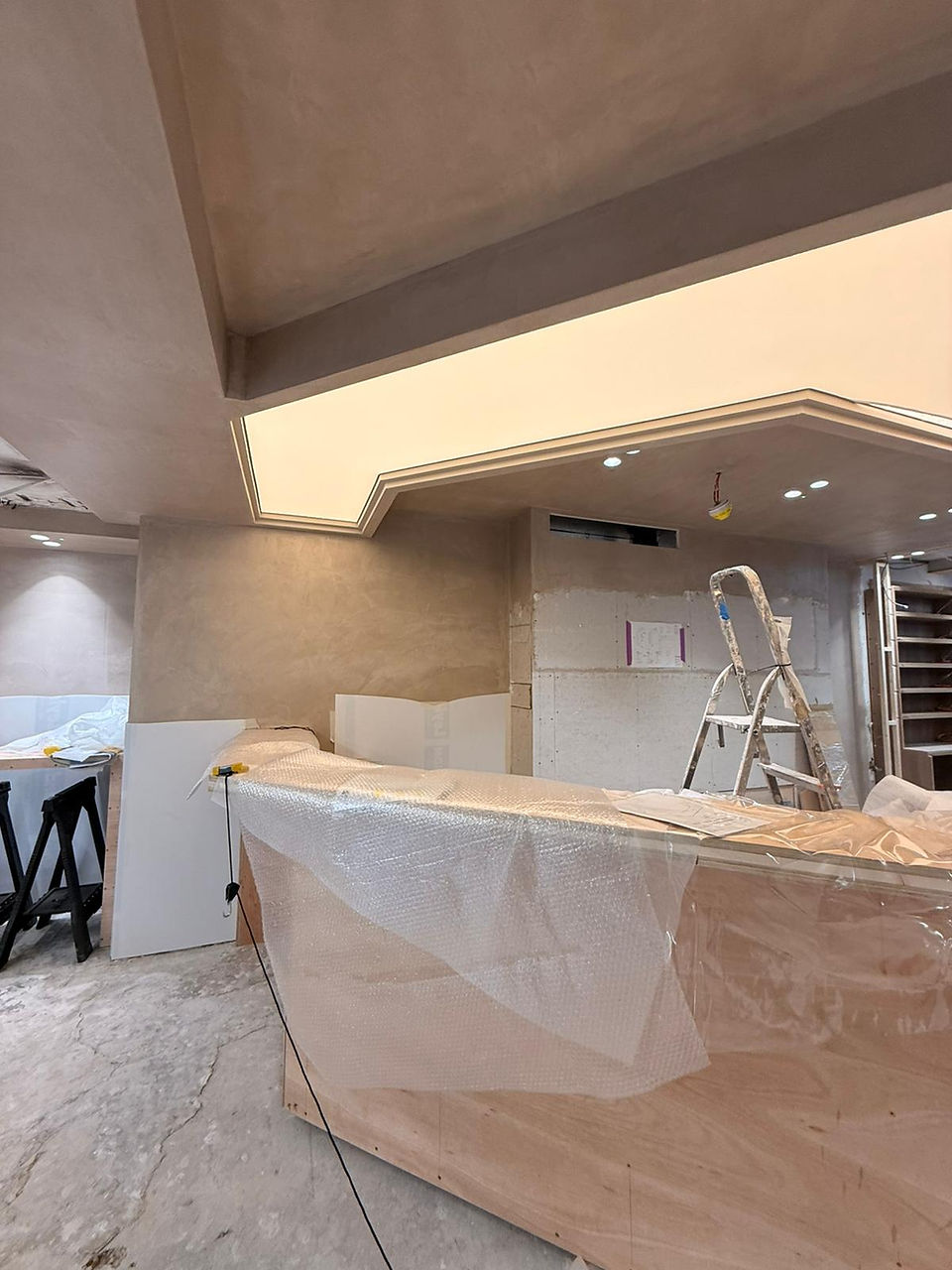 The membrane being heat-stretched into its perimeter track over the concealed LED matrix. As it cool