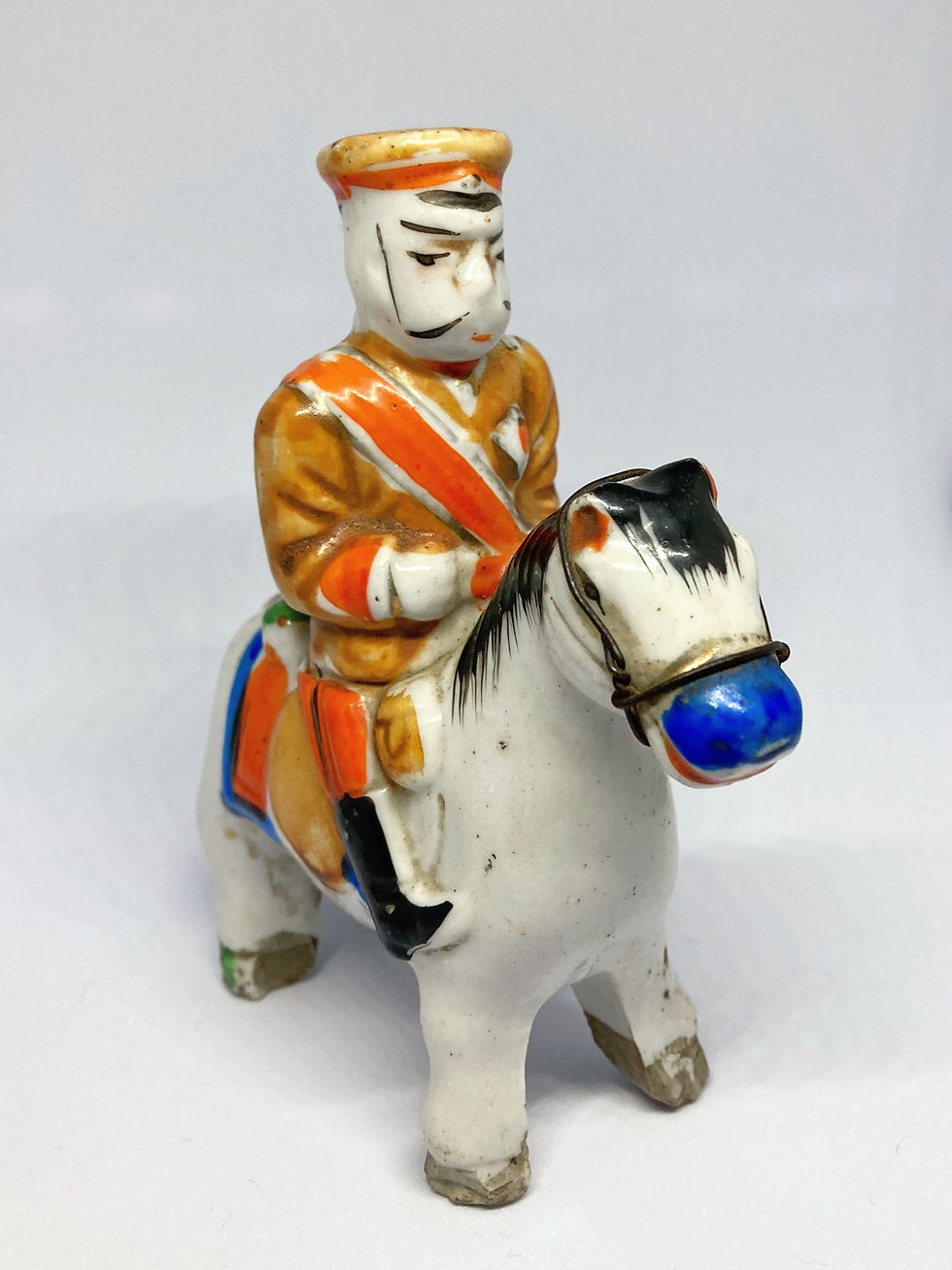 Three-quarter front view of a Taishō era Japanese polychrome porcelain equestrian figure with blue muzzle, Art San Gallery.