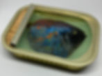 Side view of a mixed-media tin artwork showing a textured blue fish under clear resin by Ortaire de Coupigny.