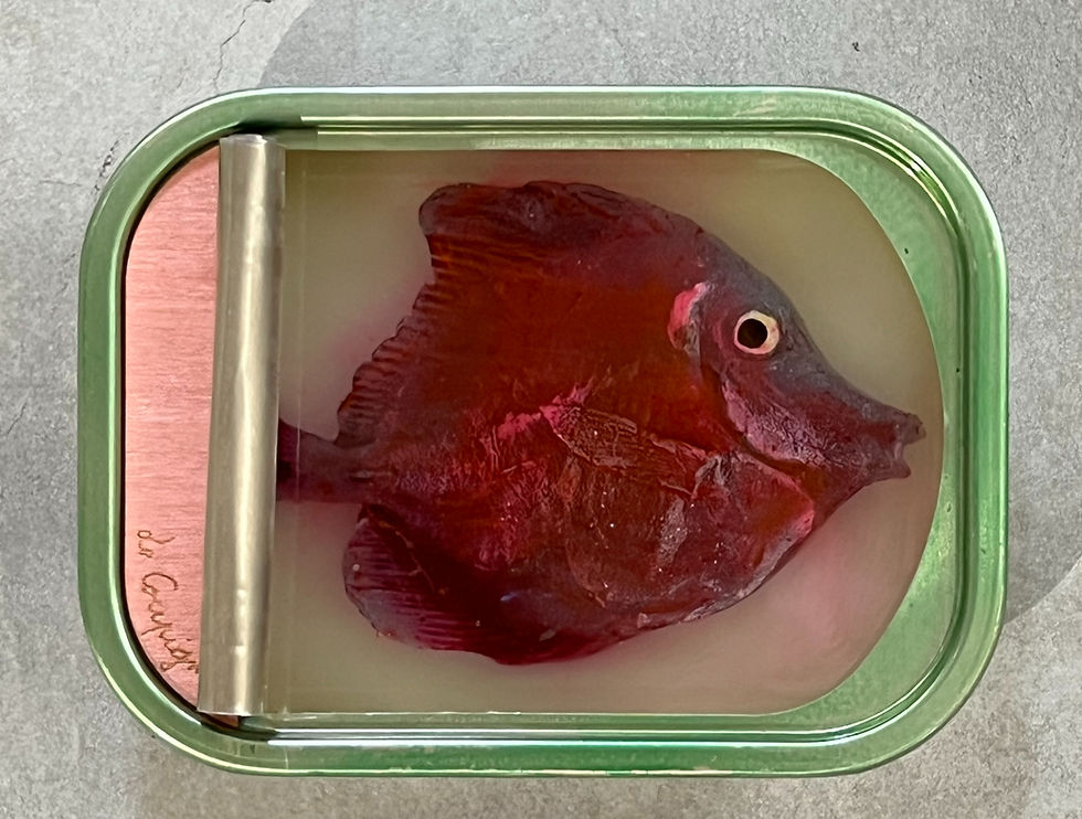 Thumbnail: Red fish sculpture by Ortaire de Coupigny in sardine can with engraved wood, set in translucent resin.