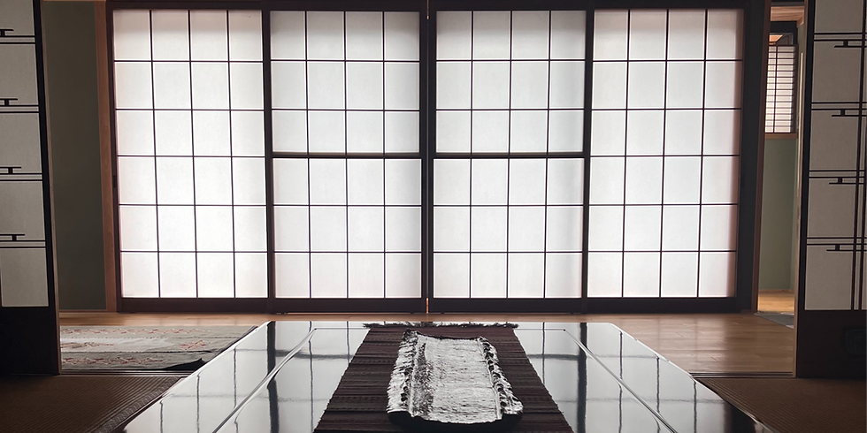 Art San Gallery’s traditional Japanese interior in Gujo Hachiman, with soft light filtering through shoji screens and reflecting on a polished wooden table.