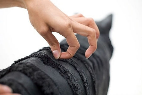 Hand of artist Haruka Miyamoto working on one of her animal sculpture made of leather