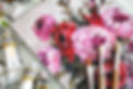 Flat lay of paints and paint brushes next to floral painting