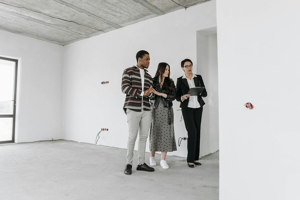 Three people in an empty room inspect the space. One holds a clipboard. The mood is serious, the walls and floor are bare, and neutral tones dominate.