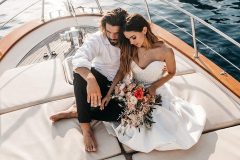 bride and groom sitting together on the front of a boat in the Amalfi coast for their elopement