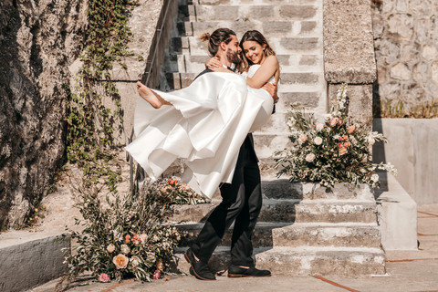 groom carrying bride on the Amalfi coast after they just got married
