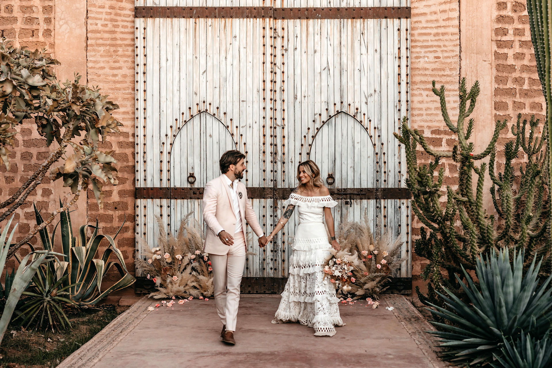 bride and groom walking together after their intimate wedding ceremony in Morocco at the Beldi Country Club a destination wedding venue in Marrakesh