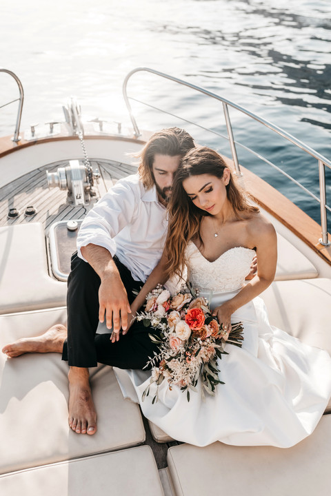 bride and groom sitting together on the front of a boat in the Amalfi coast for their elopement