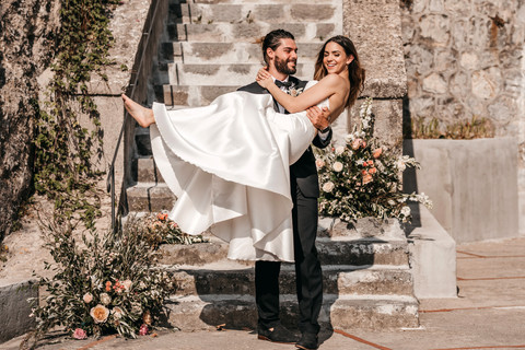 groom carrying bride on the Amalfi coast after they just got married