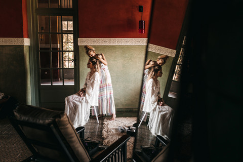 bride wearing lace robe while getting her hair and makeup done at Beldi Country Club for her Marrakech wedding