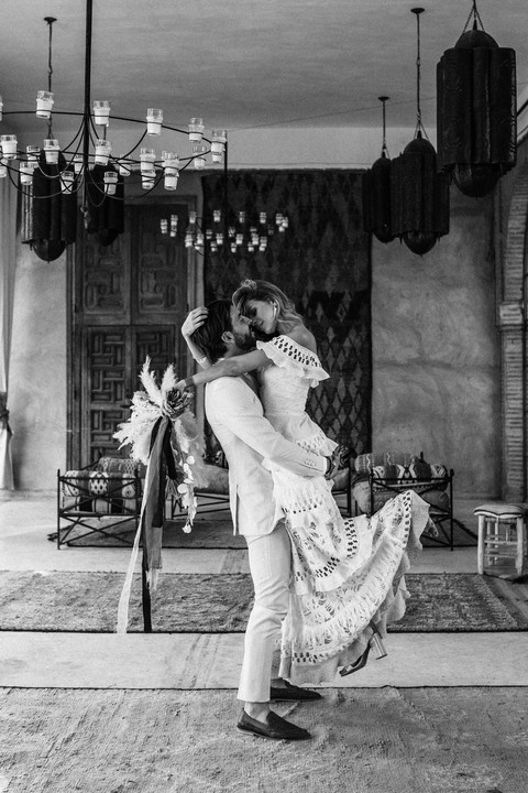 groom lifting bride in the air in a room full of moroccan rugs at Beldi Country Club in Marrakech