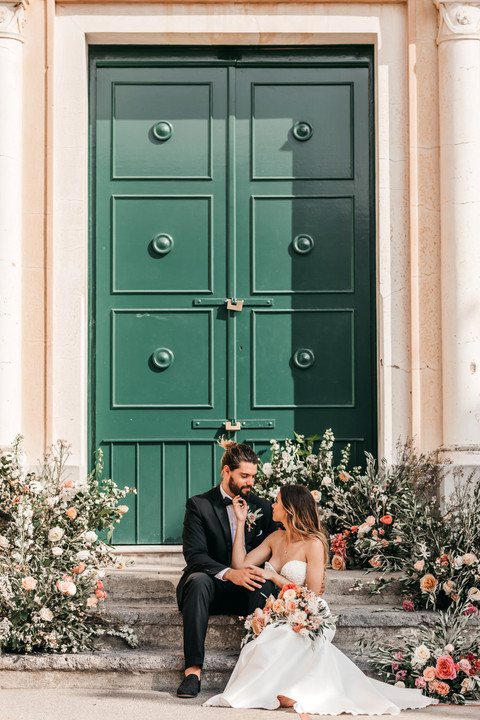couple sitting on steps decorated with roses outside a church on the Amalfi coast
