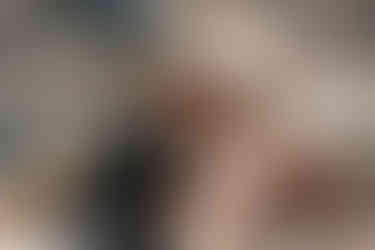 bride and groom sitting on a boat surrounded by pink roses with the houses of Positano in the background on their elopement day in the Amalfi Coast