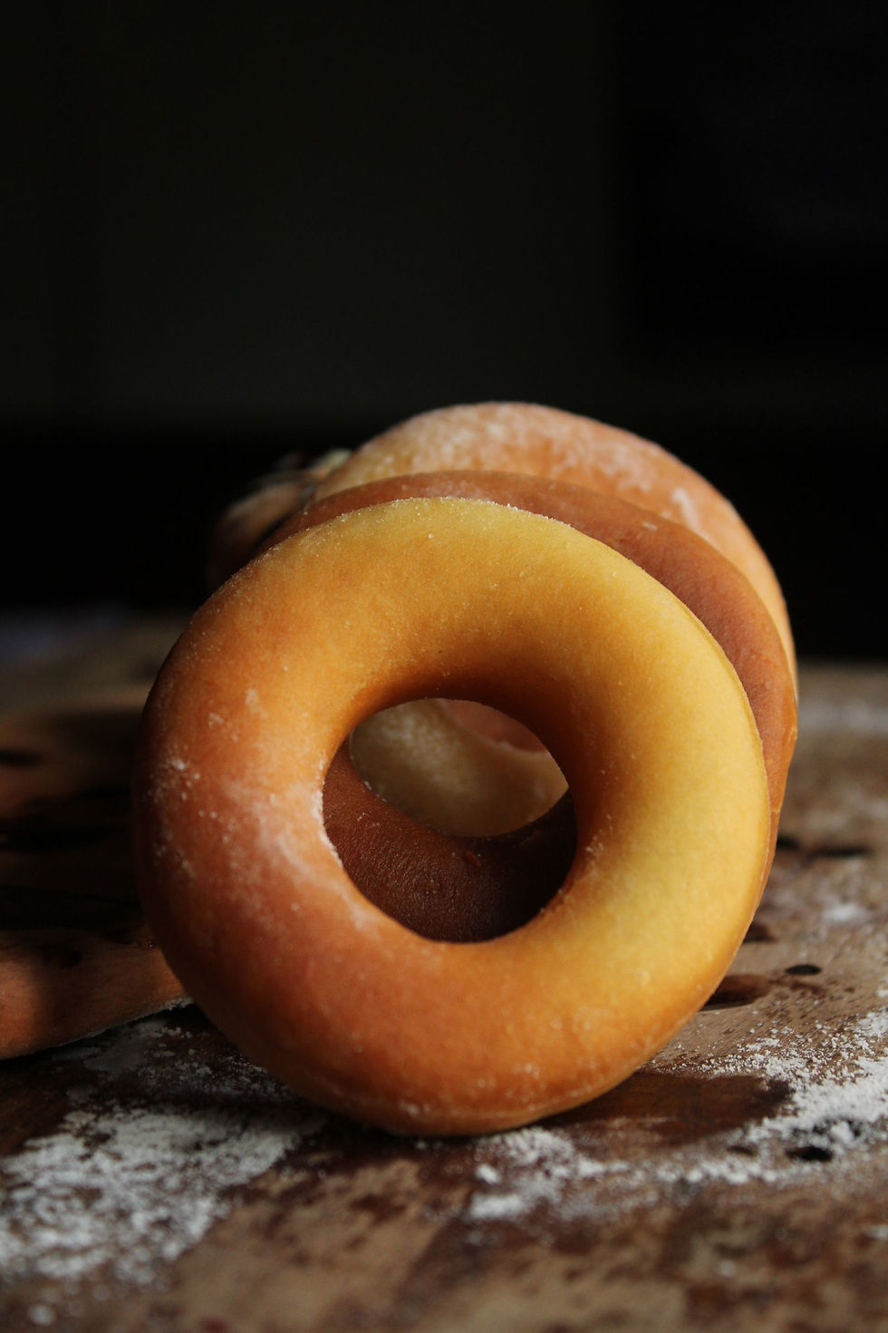Fresh sugared donuts on a rustic board, illustrating an orchard bakery's signature apple cider donut