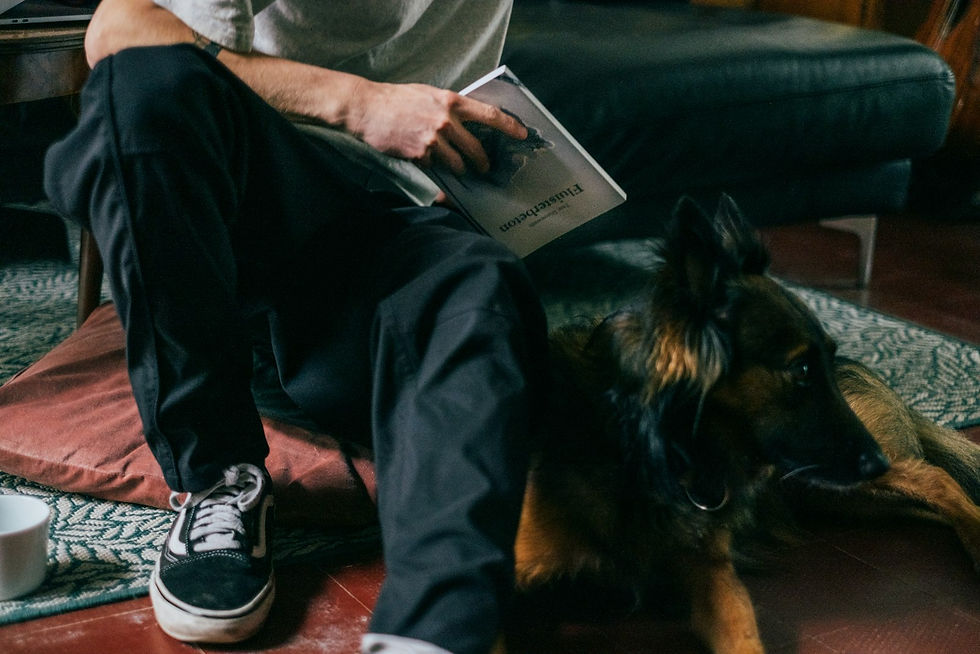 Man reading on the floor with his dog resting beside him, quiet time to bond with your dog