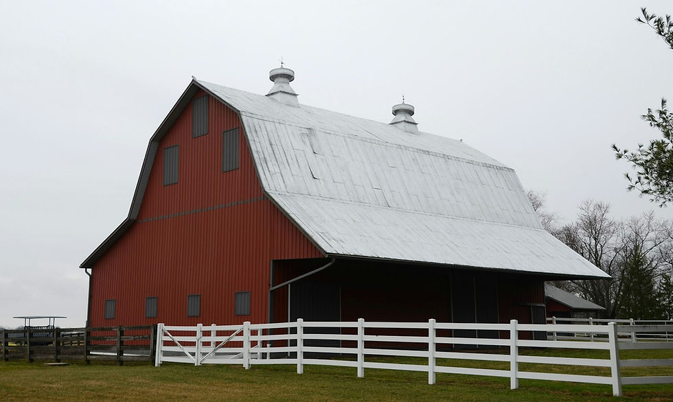 Red barn with a white fence on a quiet farm, the kind of underused building that can become an agritourism asset