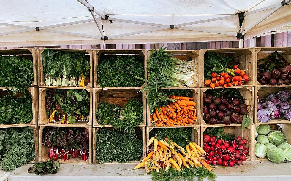 Farm stand with whole uncut vegetables in wooden crates