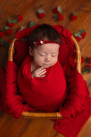 newborn baby girl wrapped in red Perth newborn photography studio portrait