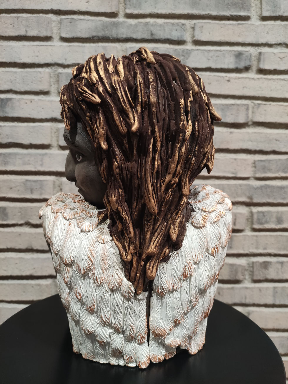 Escultura de Deseo vista por detrás, espalda de mujer con alas blancas