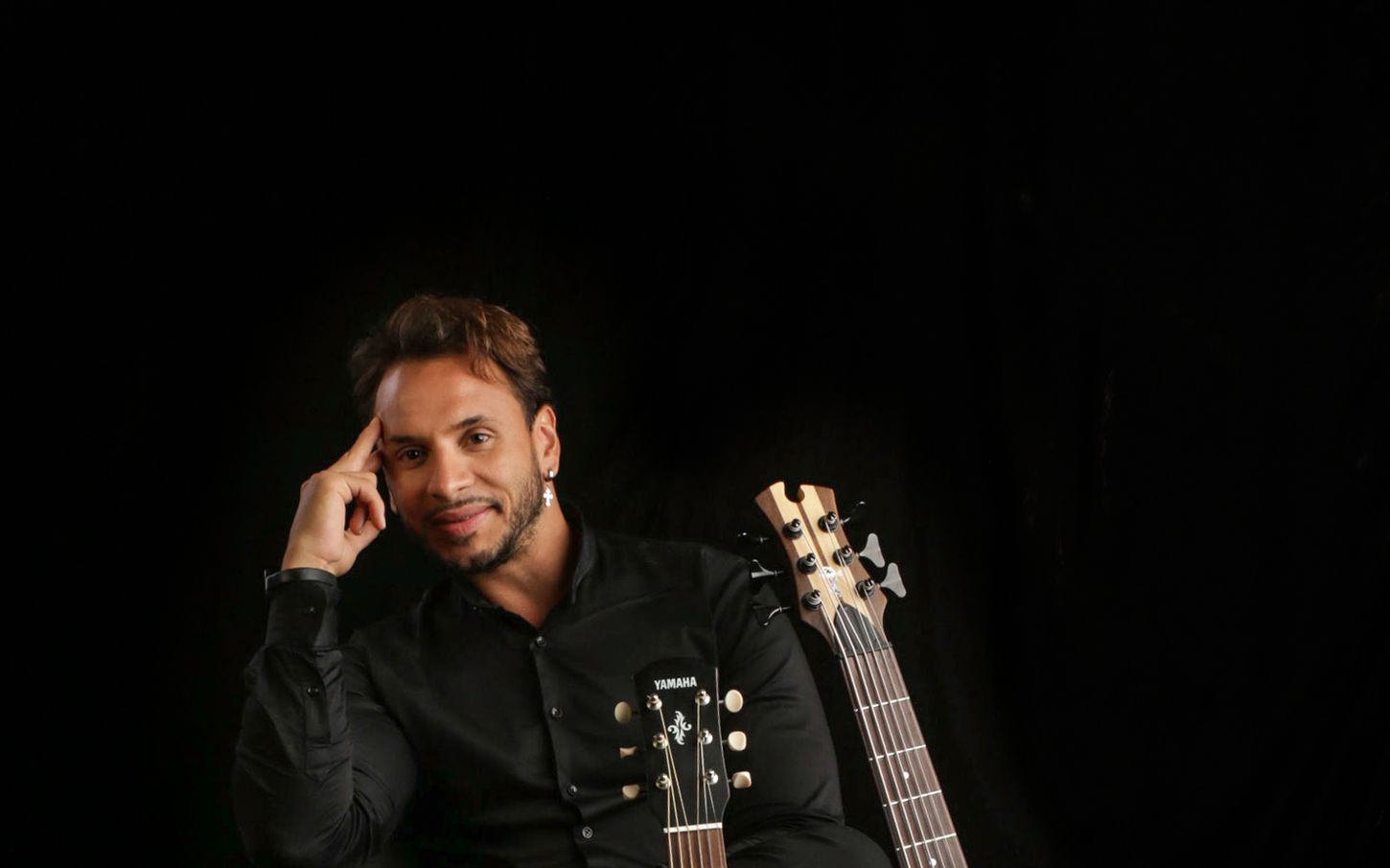 musician poses with instruments in a professional studio