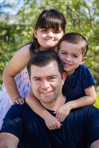 dad and two children smiling and hugging
