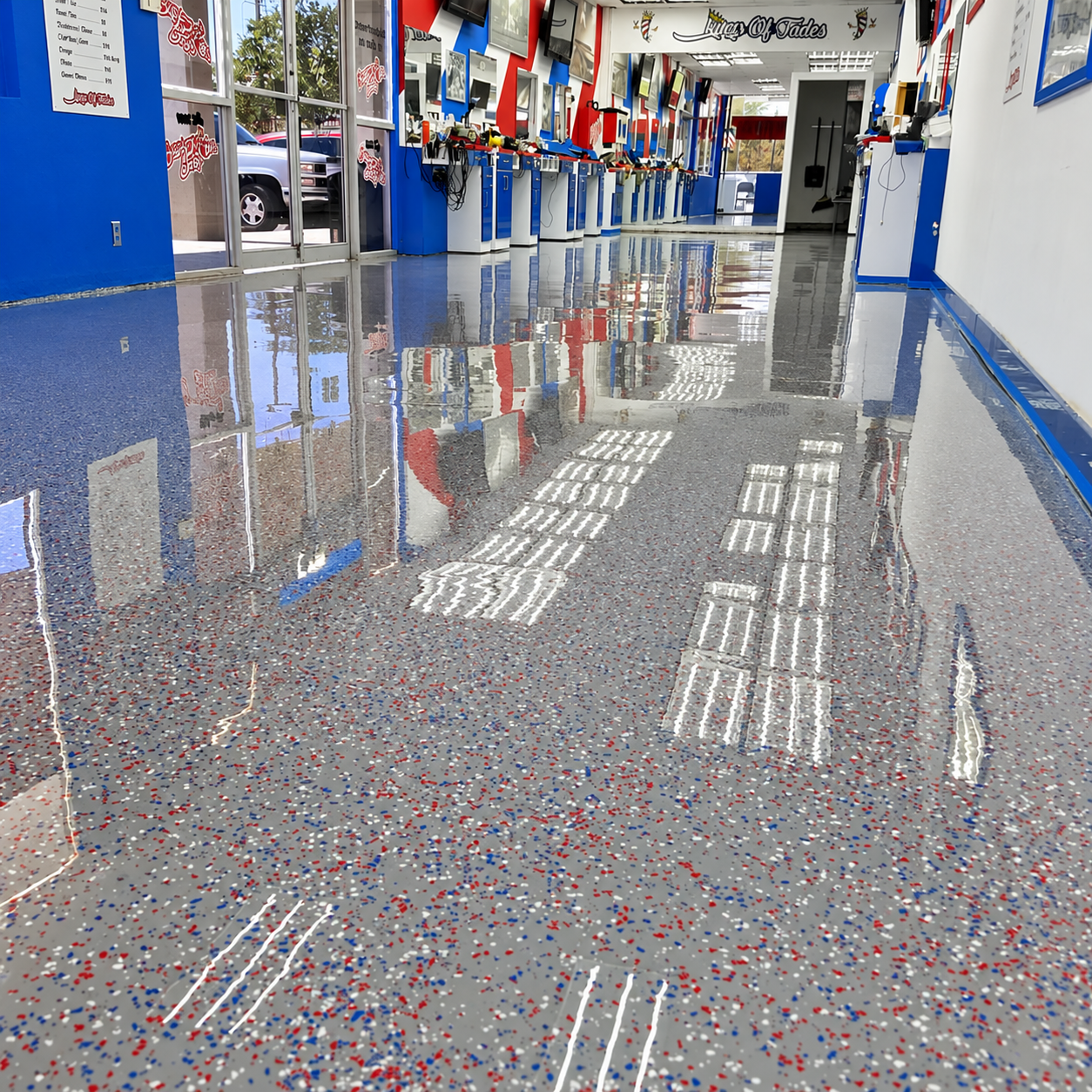 Glossy gray decorative flake floor coating with red, white, and blue flecks in a barbershop