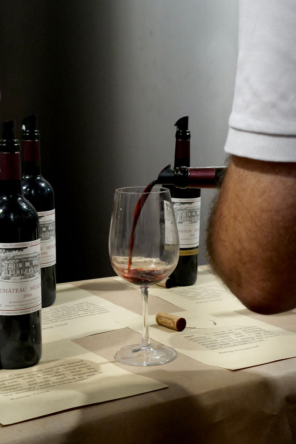 An older Bordeaux vintage being poured beside tasting notes at the 60-vintage tasting at Château Méaume