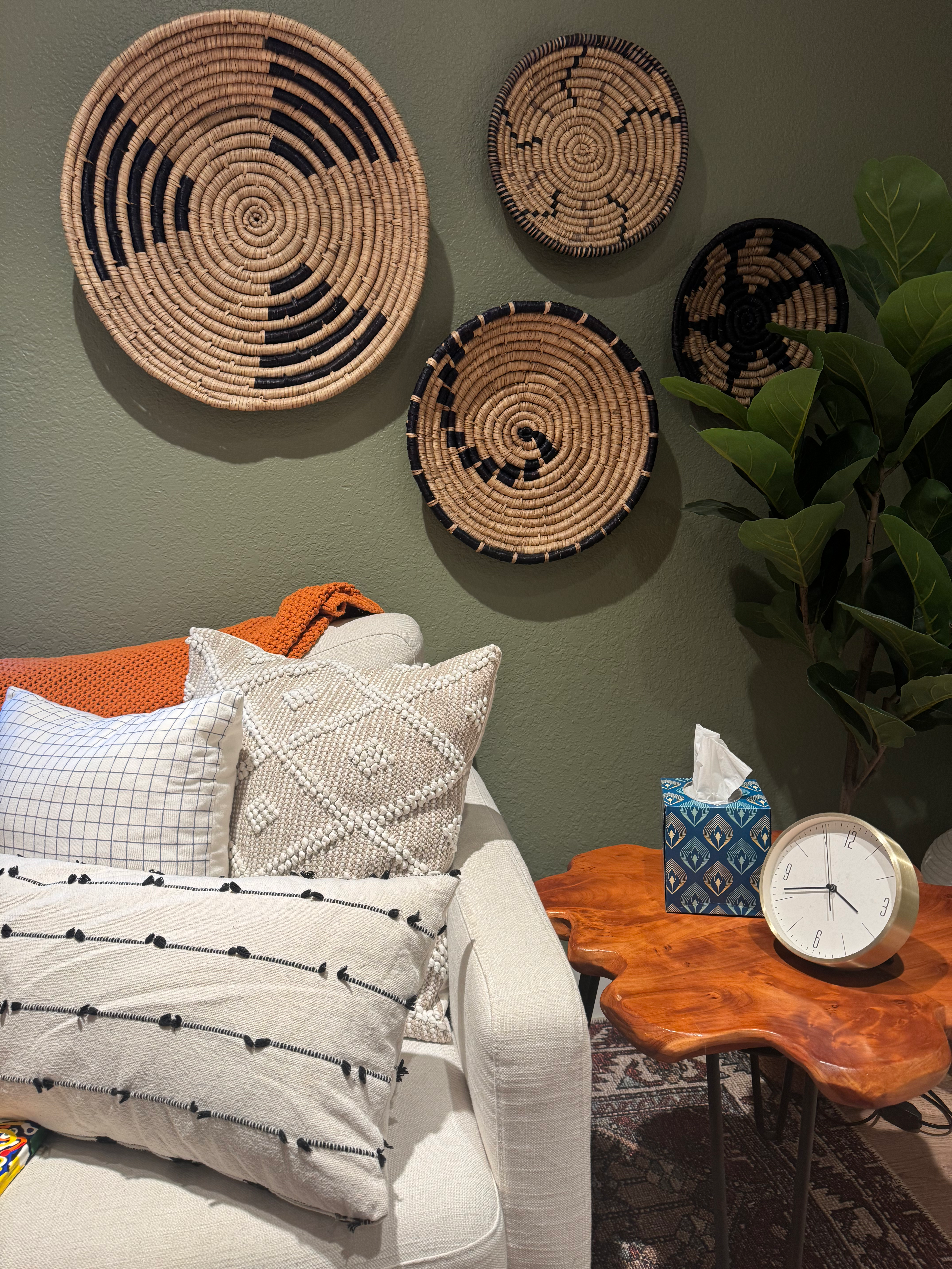 The RRT therapy room with a sofa, woven wall baskets, and warm wood side table.