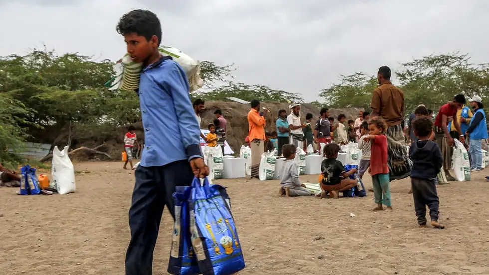 People displaced by conflict gather to receive humanitarian aid packages provided by Kuwaiti charities in the Hays area of Yemen's embattled western province in Hodeida, on 9 March 2025 (Khaled Ziad/AFP)