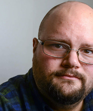 Sam - glasses and beard with neutral shadowed background