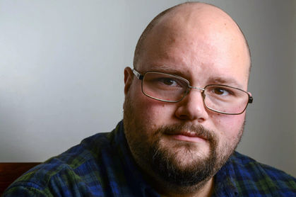 Sam - glasses and beard with neutral shadowed background