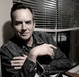 Michael Turner leans to right with blinds in background