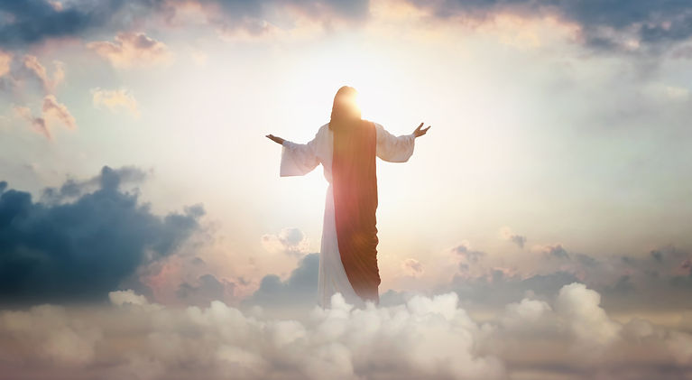 The resurrected Jesus Christ ascending to heaven above the bright light sky and clouds and
