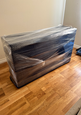 Professional movers wrapped a dresser.